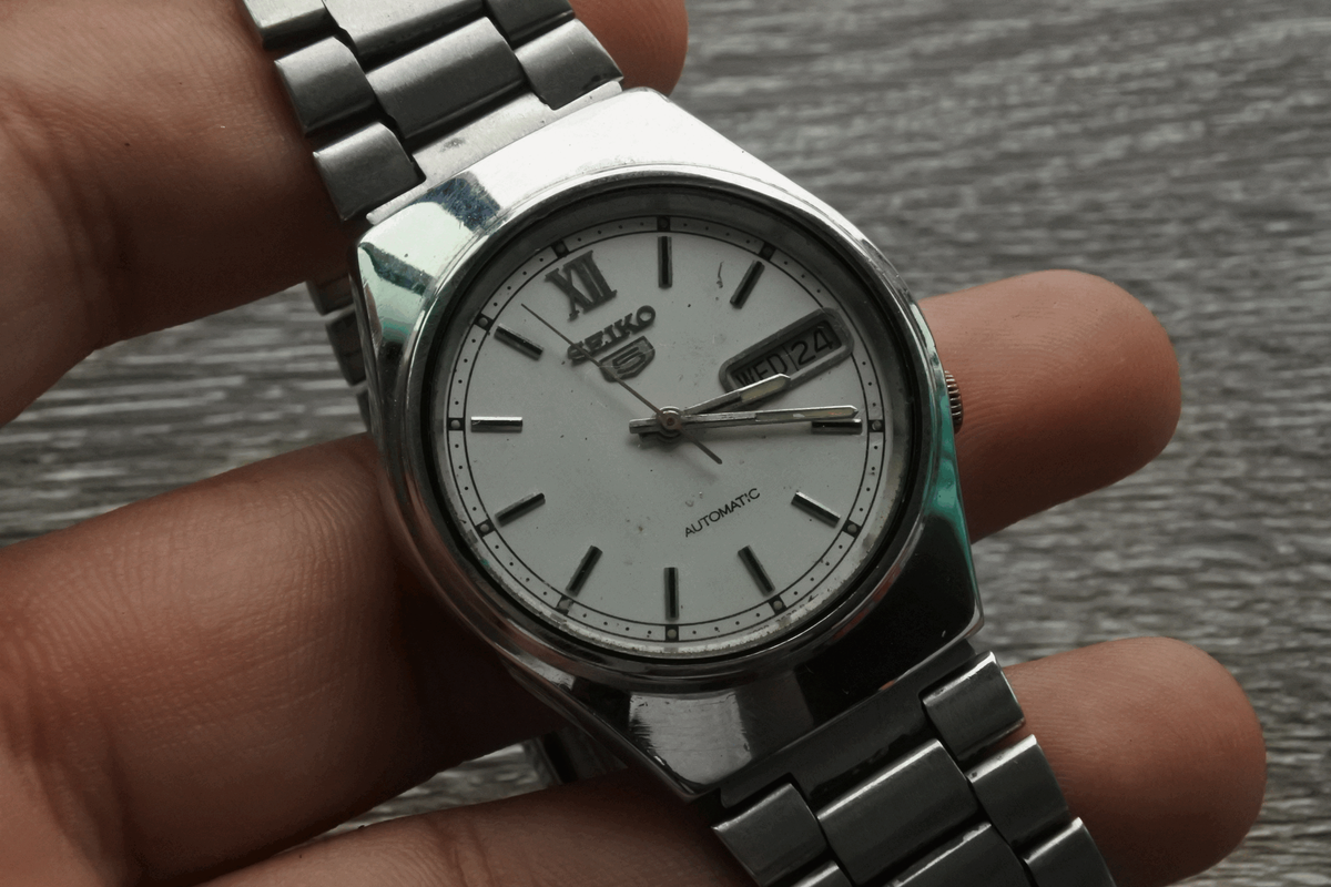 นาฬิกา Vintage มือสองญี่ปุ่น SEIKO 5 FIVE 7009 8920 ระบบ AUTOMATIC ผู้ชาย  ทรงกลม กรอบเงิน หน้าขาว หน้าปัด 35mm สายสแตนเลสแท้ ใช้งานได้ปกติ สภาพดี  ของแท้ ไม่กันน้ำ 
